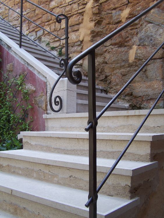 Montée d'escalier majestueuse toute en pierre et fer forgé